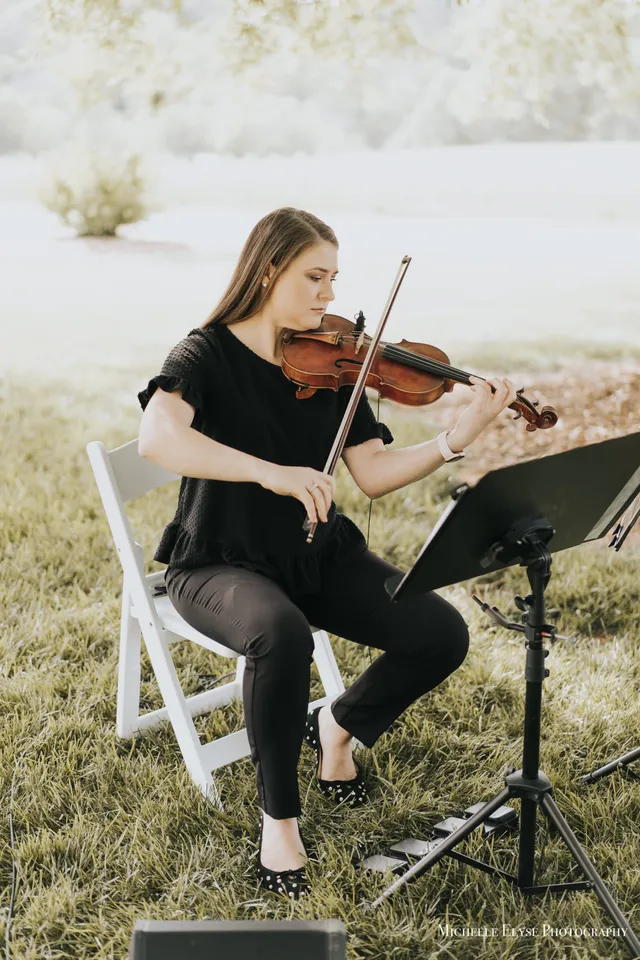 Violinist absorbed in music in soft morning garden light with dreamy bokeh background