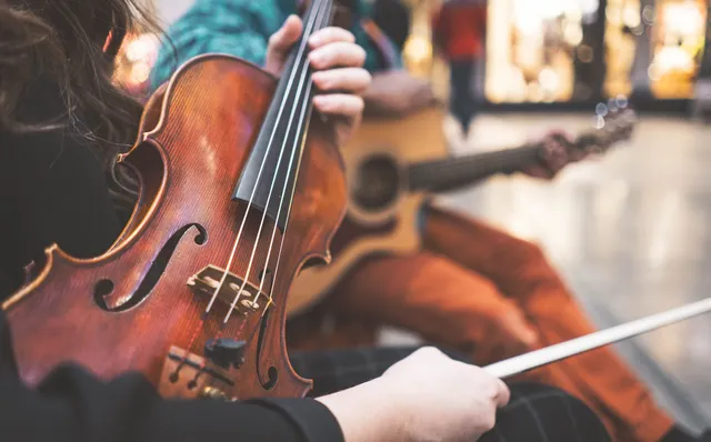 Violin and guitar close-up with golden bokeh at cocktail hour, editorial styling